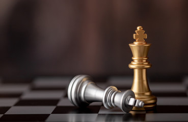 gold king standing and silver falling on chess board