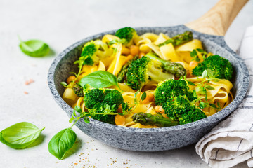 Vegetarian pasta with broccoli, asparagus and chickpeas in pan.