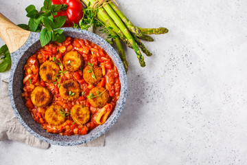 Vegetarian vegetable meatballs with tomato sauce in frying pan.