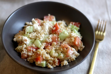 Bulgur wheat, tomato, cucumber and feta cheese salad. Selective focus.