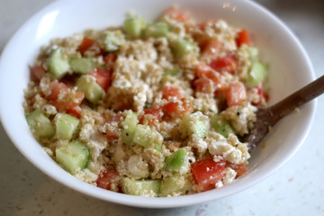 Bulgur wheat, tomato, cucumber and feta cheese salad. Selective focus.