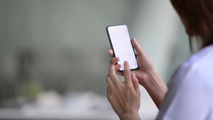Cropped image of doctor using mobile phone in hands in office