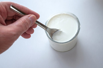 Fototapeta na wymiar A hand holding/scooping yogurt from a glass.