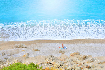 Fototapeta na wymiar One people relax on a beach of a beautiful blue sea.