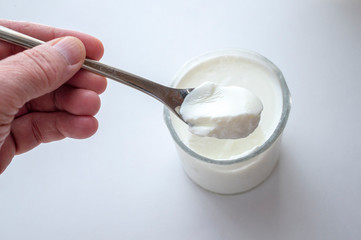 Fototapeta na wymiar A hand holding/scooping yogurt from a glass.