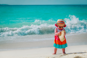 cute little girl with bag on tropical beach vacation