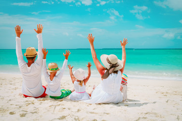 happy family with kids hands up on beach