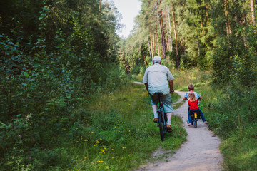 active senior with grandkids riding bikes in nature