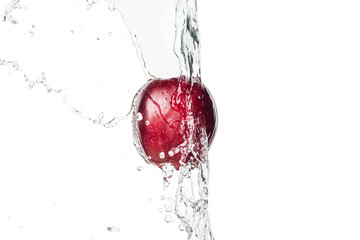 whole ripe red apple and clear water stream with drops isolated on white