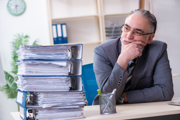 Aged male employee unhappy with excessive work 