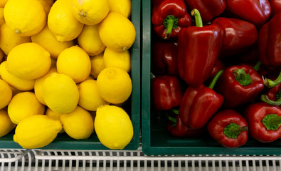 Lemon and Red peppers raw many on the basket in Supermarket.