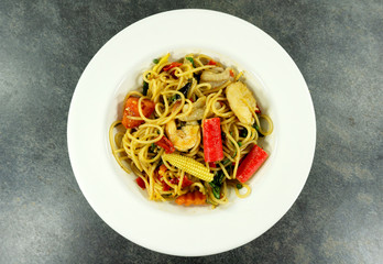 Spaghetti spicy seafood shrimp in a white dish on  stone floor table,Top view.