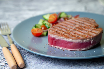 Grilled tuna steak with vegetables. Selective focus, close-up.