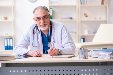 Obraz premium Old male doctor working in the clinic 
