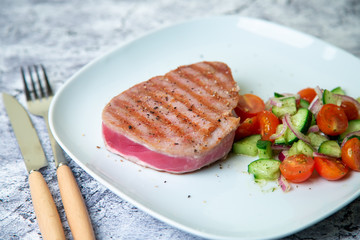 Grilled tuna steak with vegetables. Selective focus, close-up.