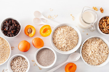 variaty of raw cereals, fruits and nuts for breakfast. Oatmeal flakes and steel cut, barley, walnut, chia, apricot. Healthy ingredients
