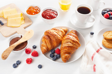 Continental breakfast with croissant, jam, chocolate spread and coffee