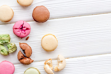 Fototapeta na wymiar Macarons dessert pattern on white wooden background top view copy space