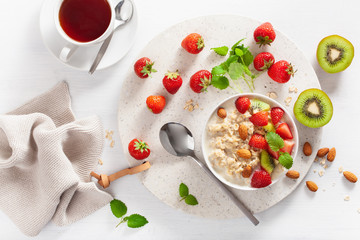 healthy breakfast oatmeal porridge, strawberry, nuts. Top view