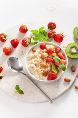 healthy breakfast oatmeal porridge, strawberry, nuts. Top view