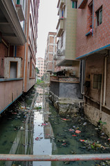 Fototapeta na wymiar rubbish refuse garbage in water between buildings in a village in guangzhou