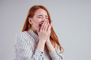 Flu cold or allergy symptom. Sick young redhead business woman sneezing in tissue on white Studio