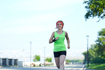 Running woman on the waterfront. Morning jogging. The athlete trains