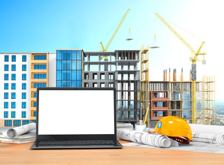 Desktop with an open laptop, construction drawings in rolls, construction helmet on the background of construction. 3D illustration