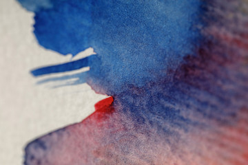 Fototapeta premium close up view of blue and red watercolor paint spills on white background
