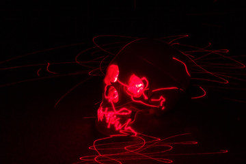 red laser pointer illuminating a human skull