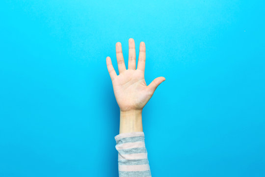 Person raising their hand up on a blue background