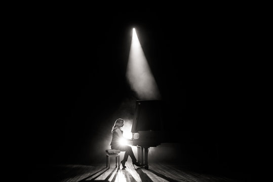 Young Musician Playing The Grand Piano On The Stage