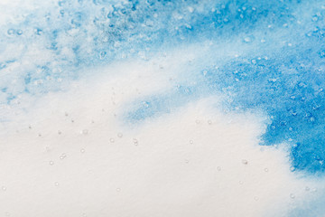 blue colorful watercolor paint spill on white textured background with copy space