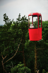 Flying red cabin on the green tree background in summer. Copy space.