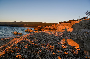 Naklejka premium sunrise over a stone beach in Rabac Croatia