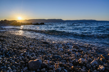 sunrise over a stone beach in Rabac Croatia