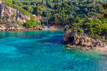 Fototapeta na wymiar Beautiful landscape with sea, mountains and cliffs, green trees and bushes, rocks in a blue water. Corfu Island, Greece. 