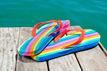 rainbow flip-flops on a weathered dock