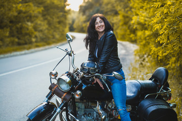 Fototapeta na wymiar attractive brunette motorcyclist sits on a motorcycle. adventure concept