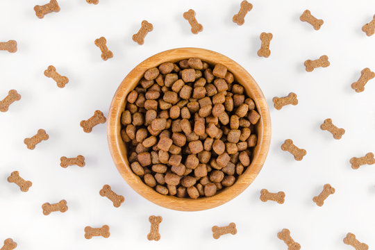 dog food in a bowl and snack like bones on white background, flat lay