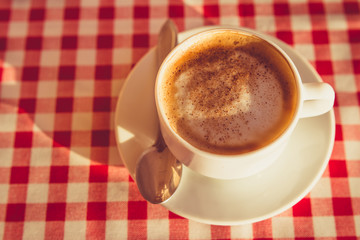 A Cup of cappuccino is on the table in the cafe 