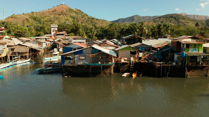 Fototapeta na wymiar Old wooden house standing on the sea in the fishing village. Busuanga, Coron, Philippines. houses community standing in water in fishing village. Coron city with slums and poor district.