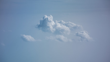 Aerial view from plane window with blue sky and white clouds