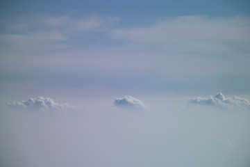 Aerial view from plane window with blue sky and white clouds