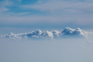 Aerial view from plane window with blue sky and white clouds