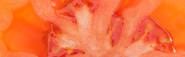 close up view of red ripe fresh tomato half with seeds, panoramic shot