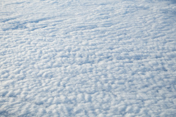 Aerial view from plane window with blue sky and white clouds