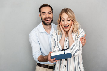 Photo closeup of happy man in casual clothing smiling and giving present to his girlfriend