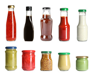 Set of glassware with different delicious sauces on white background