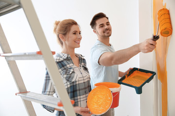 Happy couple painting wall indoors. Home repair © New Africa